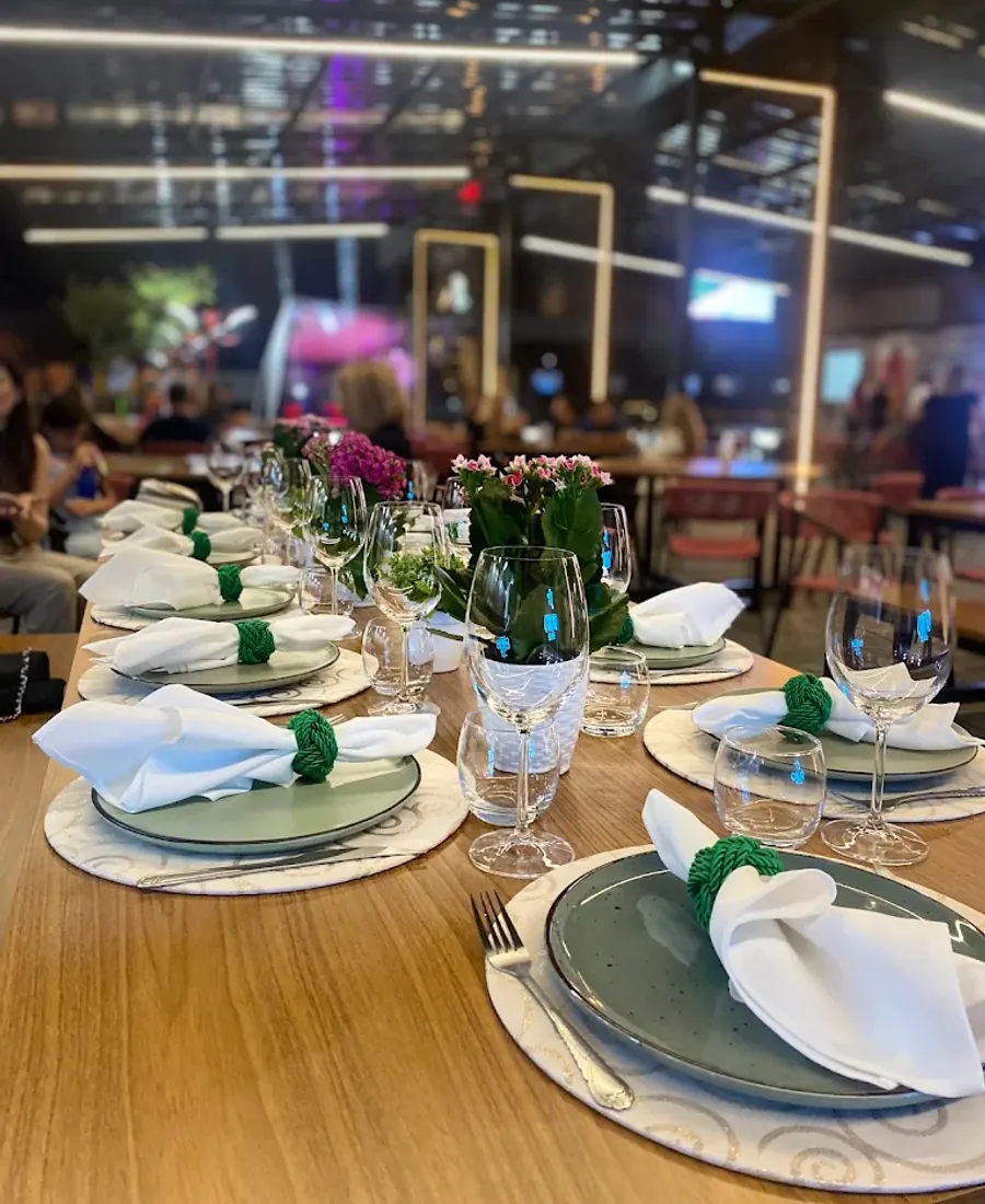 Mesa preparada com taças e louça para grupo no Havilah Bistrô